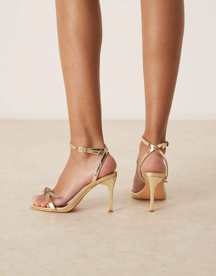 Glamorous stiletto heeled sandals with embellished bow in gold - Image 4